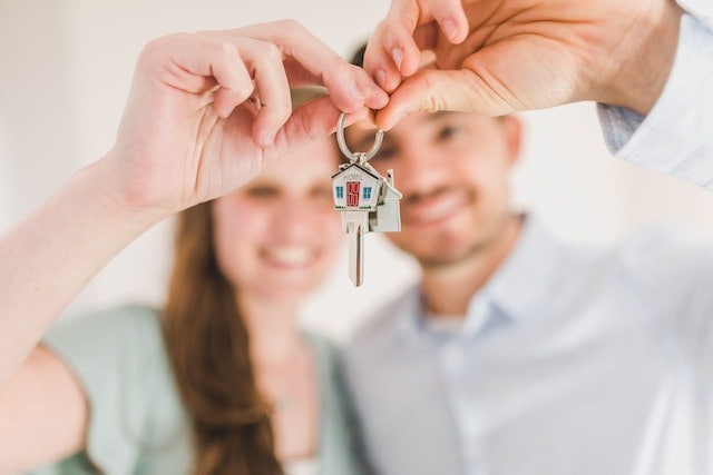 Couple holding house keys for how to buy a house in California first-time buyer